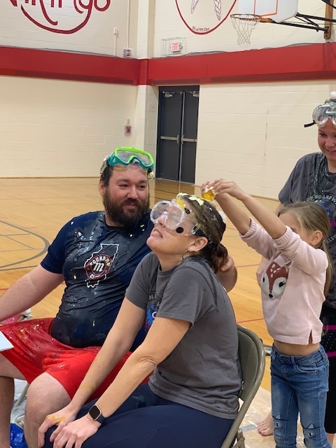 Picture of teachers having eggs cracked on their heads.  